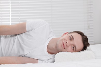 Man lying on orthopedic pillow at home