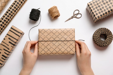 Photo of Woman decorating gift box on white background, top view