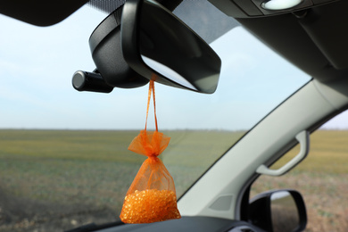 Photo of Air freshener hanging on rear view mirror in car