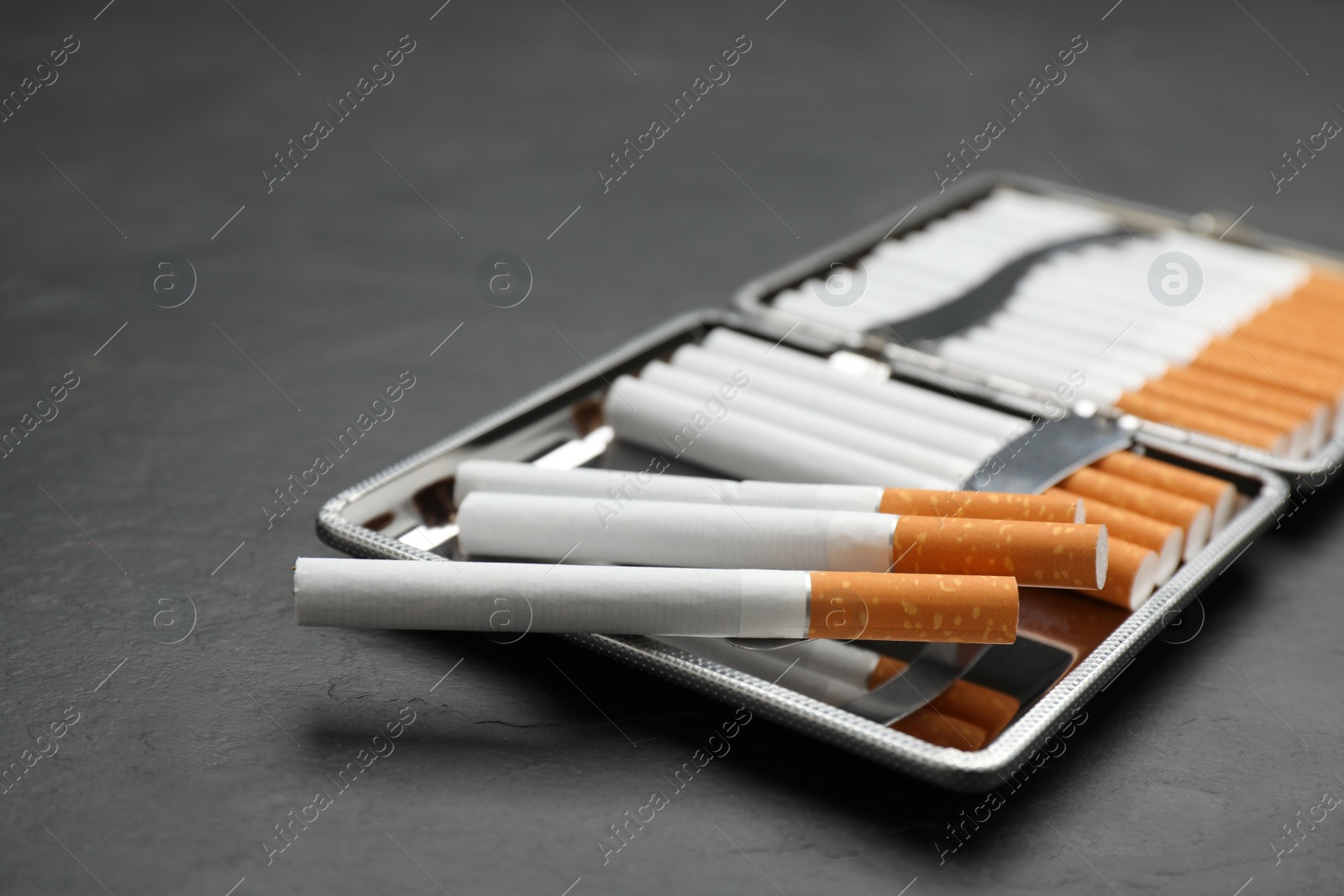 Photo of Stylish case with cigarettes on black table, closeup