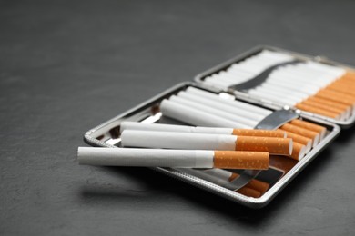 Stylish case with cigarettes on black table, closeup