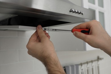 Photo of Worker repairing modern cooker hood in kitchen, closeup