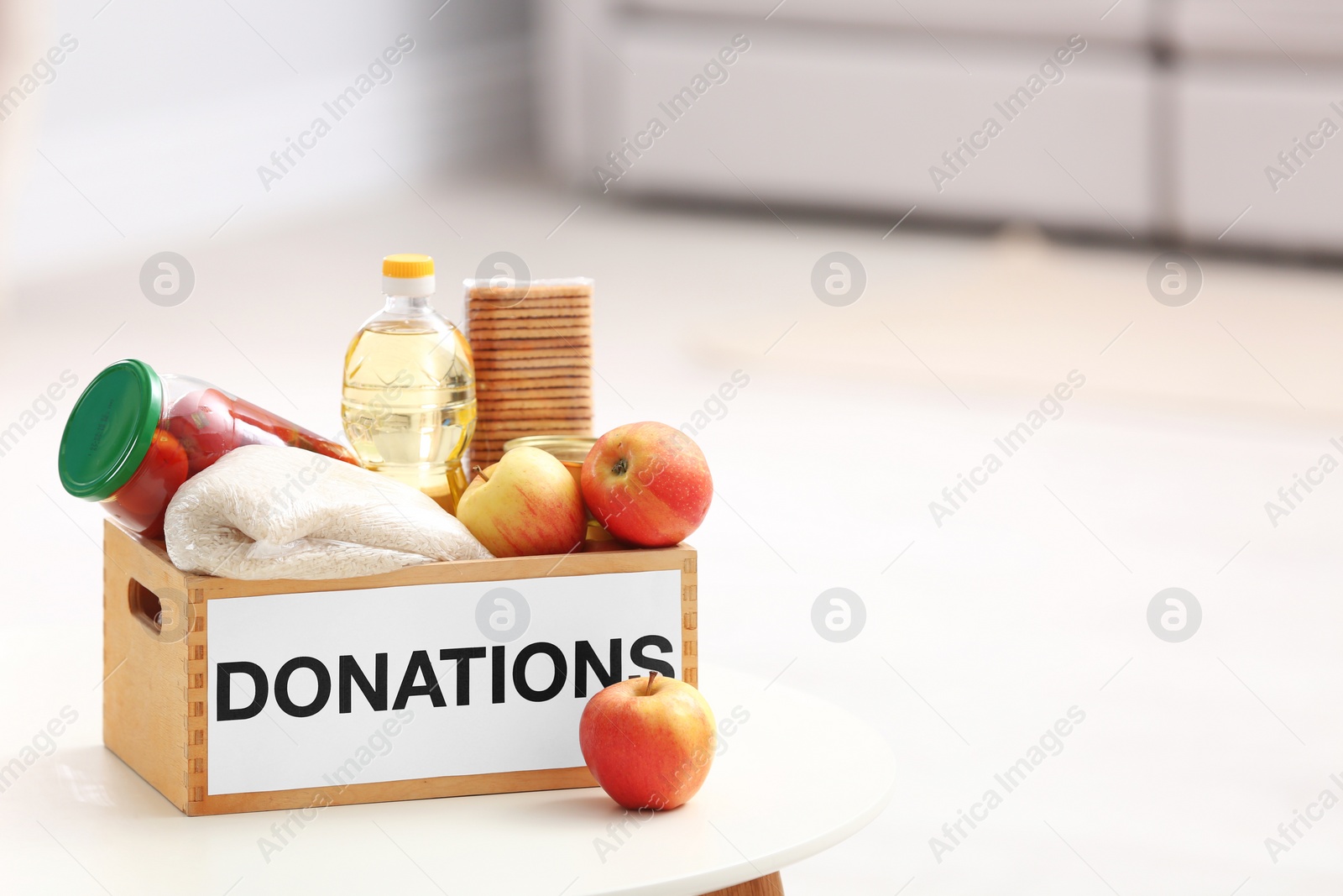 Photo of Donation box with food products on table indoors