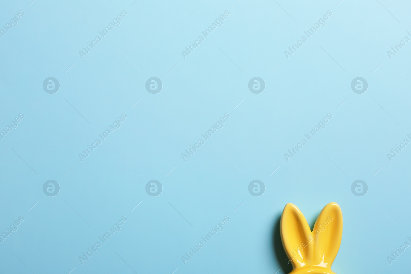 Photo of Easter bunny ears on color background, top view. Space for text