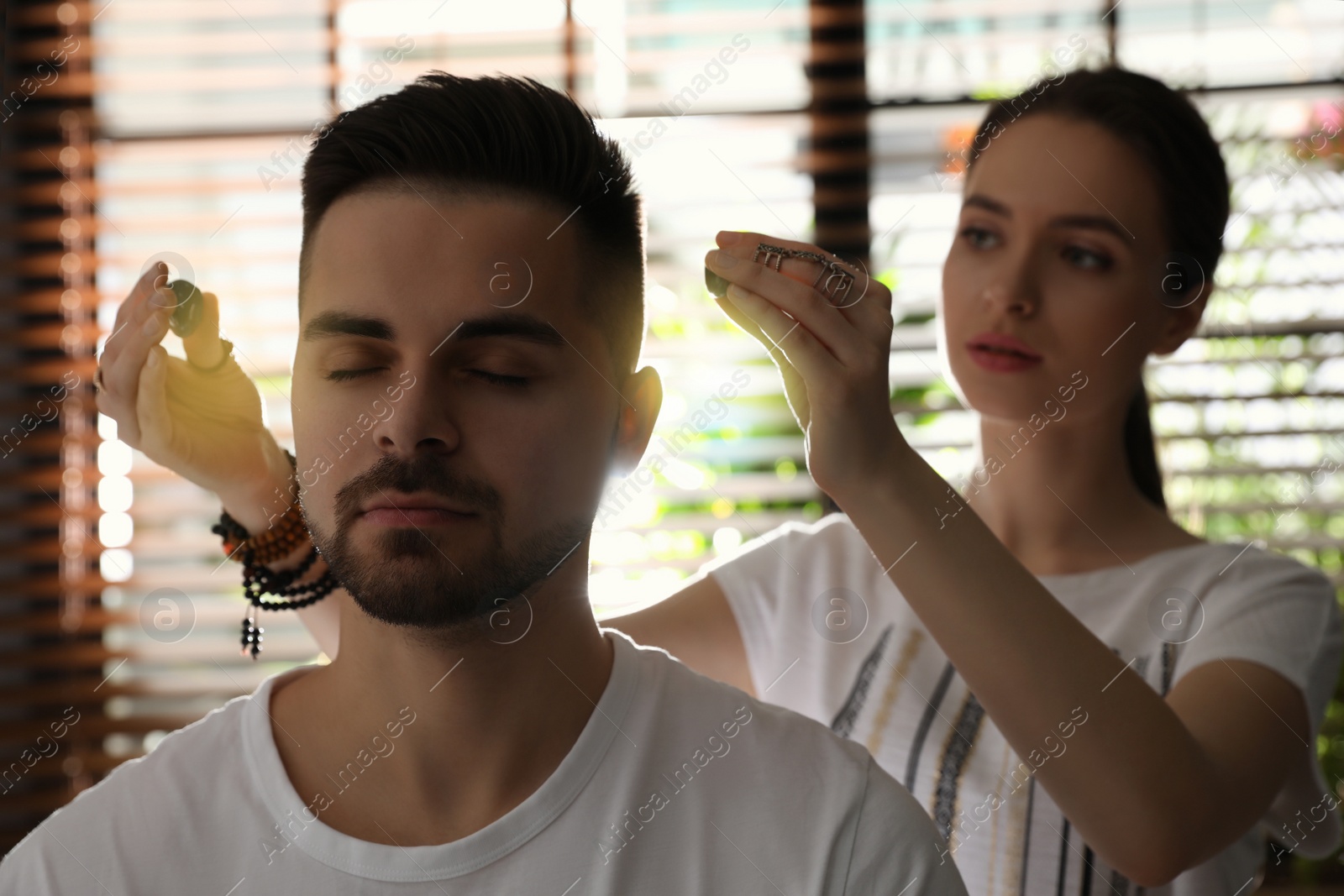 Photo of Young man during crystal healing session in therapy room