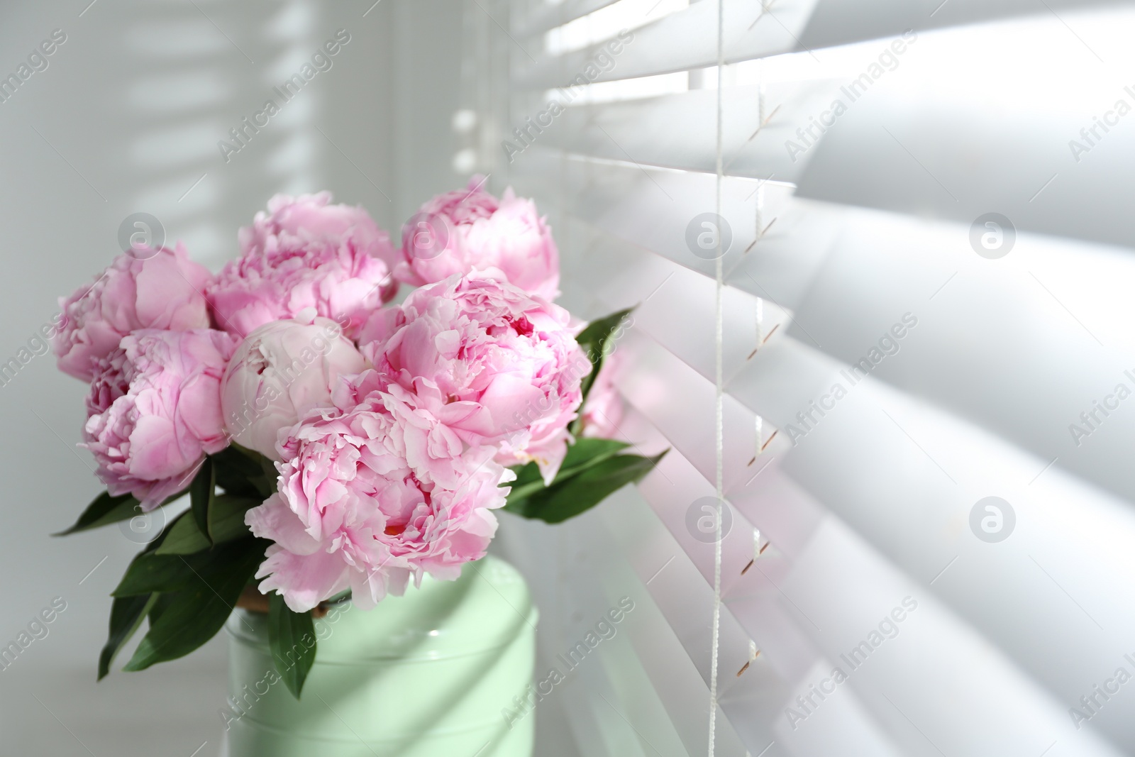 Photo of Bouquet of beautiful peonies near window, closeup. Space for text