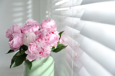 Photo of Bouquet of beautiful peonies near window, closeup. Space for text