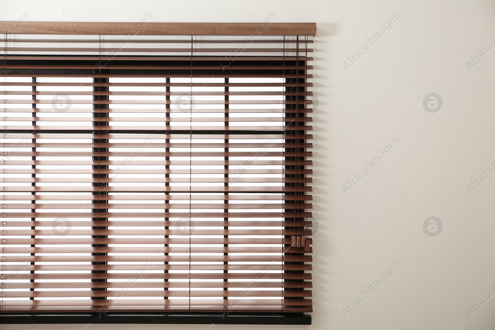 Photo of Modern window with stylish wooden blinds indoors. Space for text