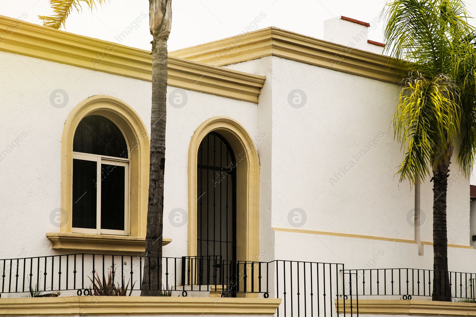 Photo of Entrance of residential house with door, potted plants and window