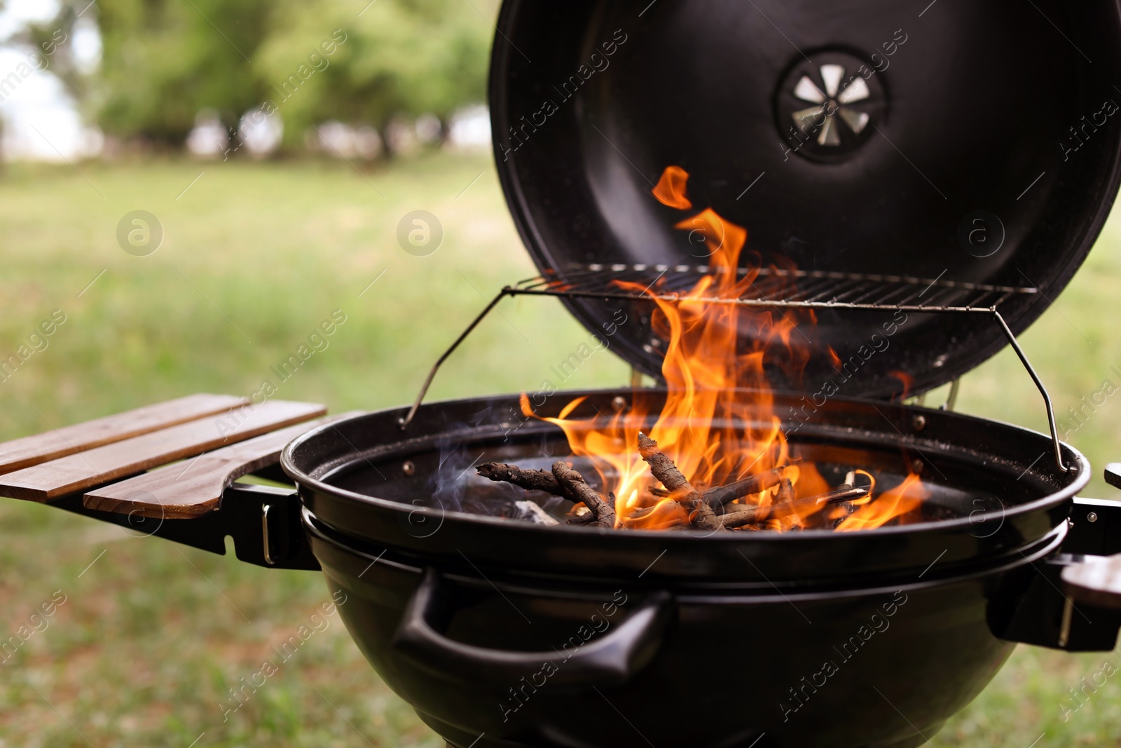 Photo of Modern barbecue grill with fire flames outdoors