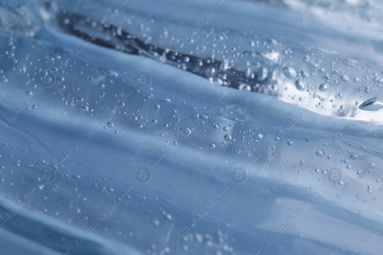 Photo of Texture of light blue shower gel as background, closeup