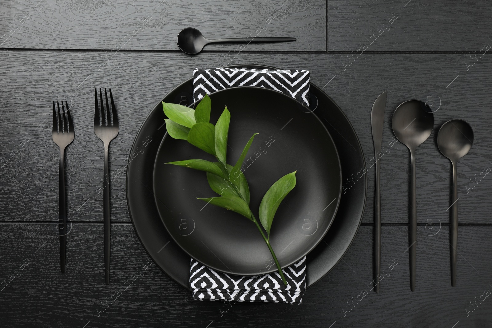 Photo of Stylish setting with cutlery and plates on black wooden table, flat lay