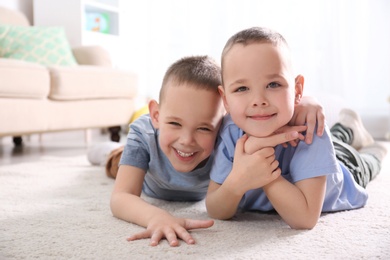 Photo of Portrait of cute twin brothers on floor in living room