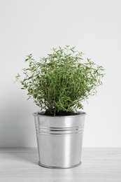 Photo of Aromatic green potted thyme on white wooden table
