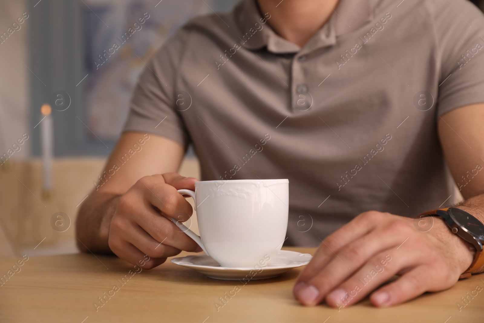 Photo of Man with cup of coffee at cafe in morning, closeup