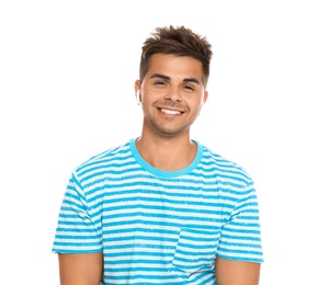 Happy young man listening to music through wireless earphones on white background