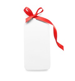 Blank gift tag with red satin ribbon on white background, top view