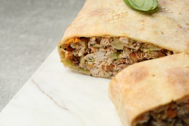 Delicious strudel with chicken and vegetables on grey table, closeup