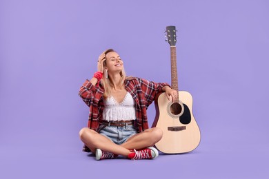Photo of Happy hippie woman with guitar on purple background
