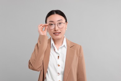 Portrait of smiling businesswoman on grey background