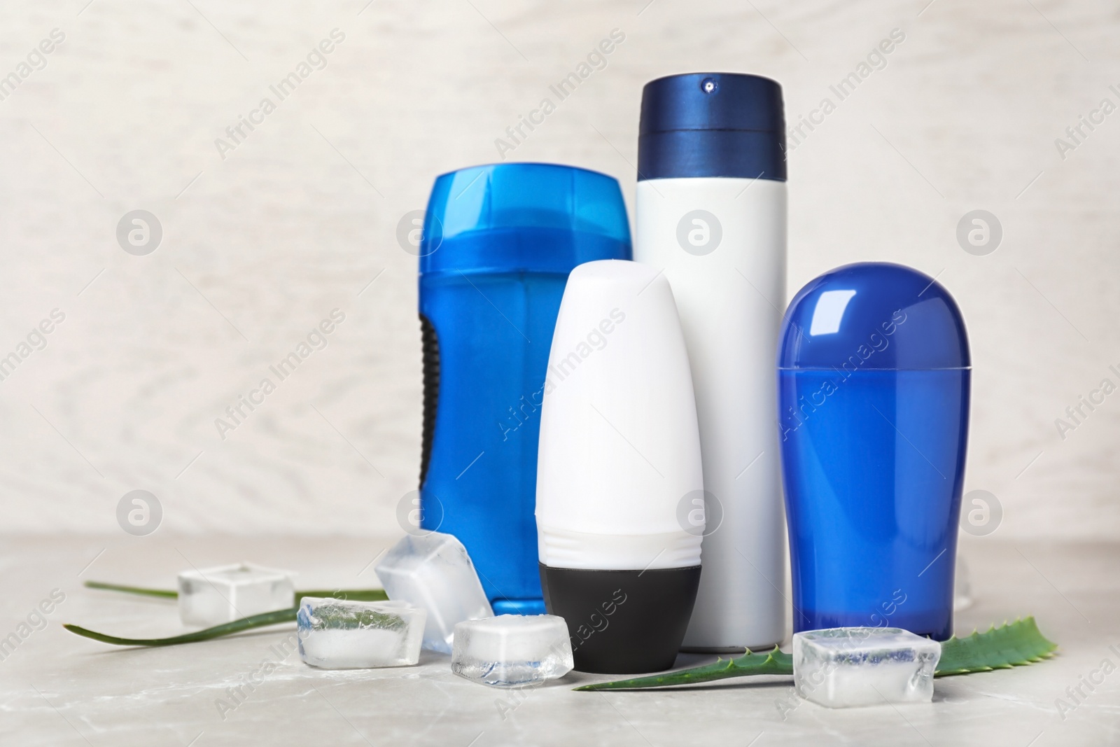 Photo of Different deodorants, ice cubes and aloe on table. Personal hygiene