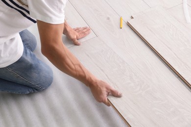 Man installing new laminate flooring, closeup view