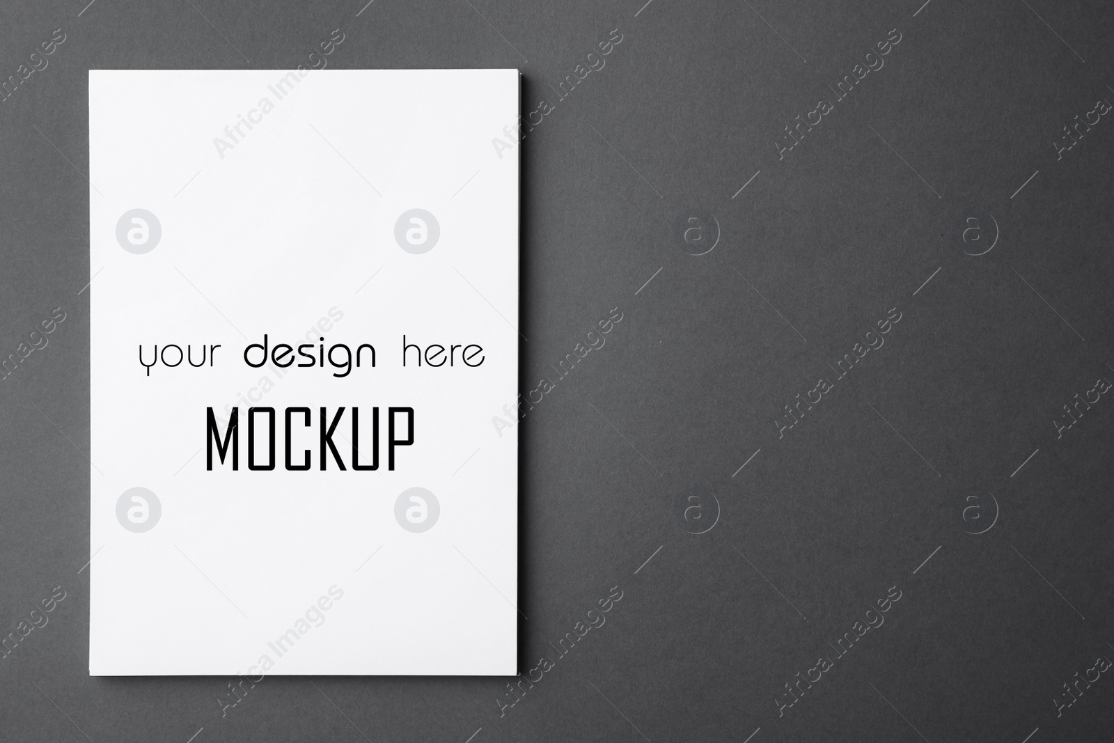 Image of Paper sheet with text Mockup Your Design Here on dark grey background, top view