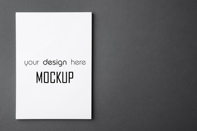Image of Paper sheet with text Mockup Your Design Here on dark grey background, top view