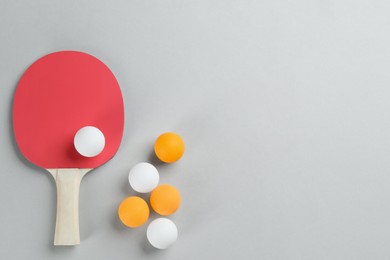 Photo of Ping pong racket and balls on grey background, flat lay. Space for text