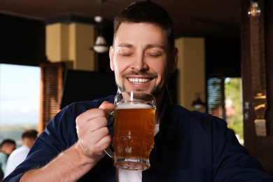 Man with glass of tasty beer in pub