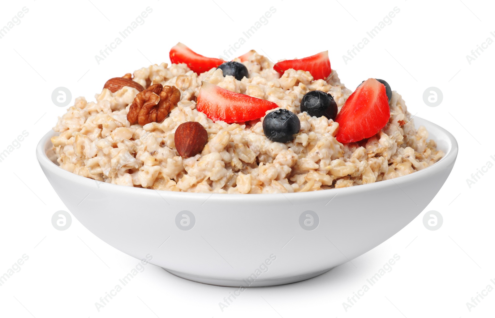 Photo of Tasty boiled oatmeal with berries and nuts in bowl isolated on white