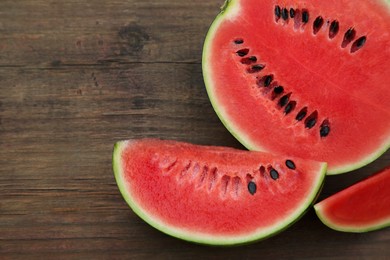 Delicious cut ripe watermelons on wooden table, flat lay