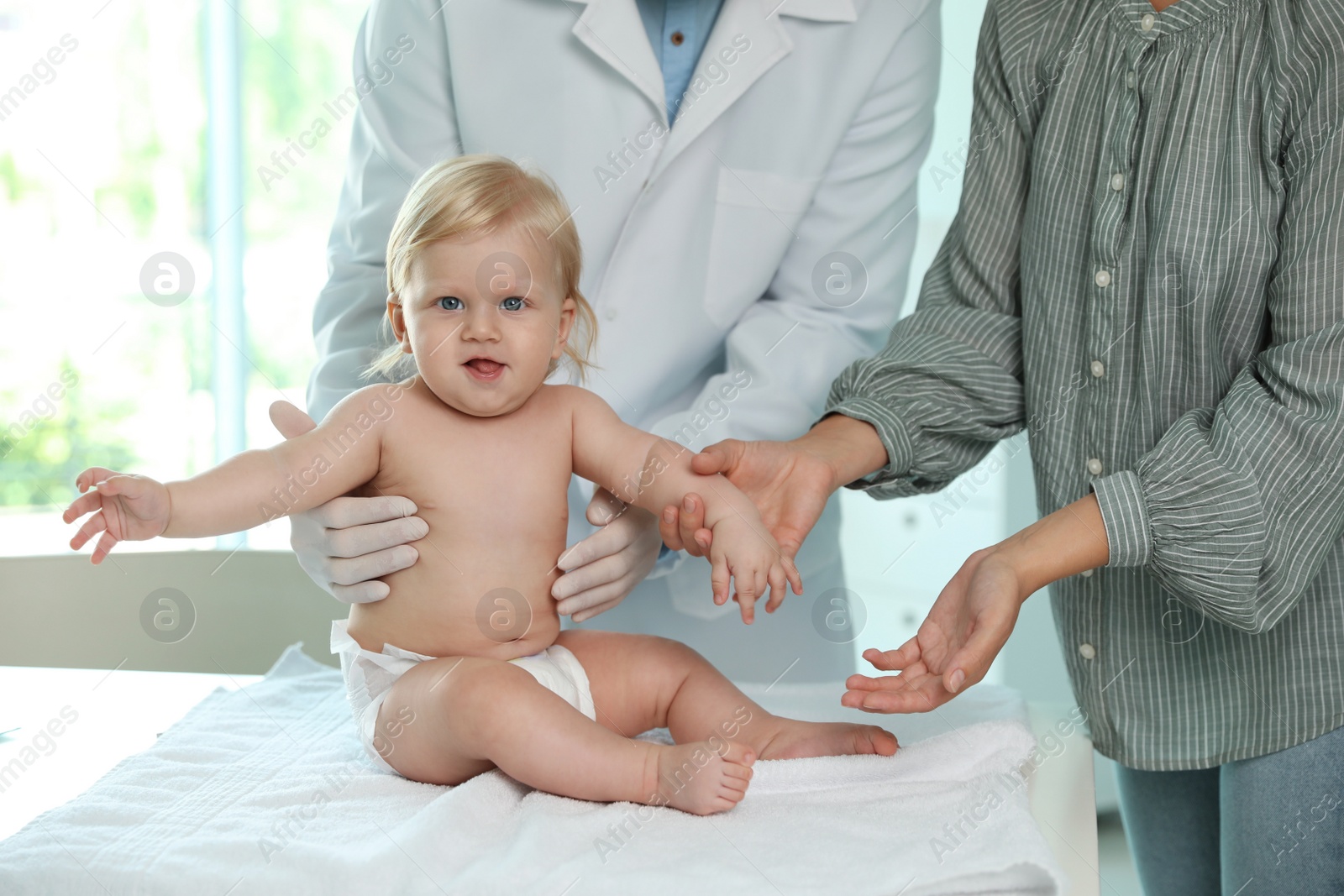 Photo of Mother with her baby visiting pediatrician in hospital. Health growth