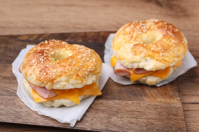 Photo of Delicious bagels with ham and cheese on table, closeup