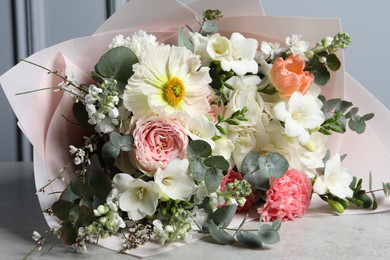 Photo of Bouquet of beautiful flowers on light grey table, closeup