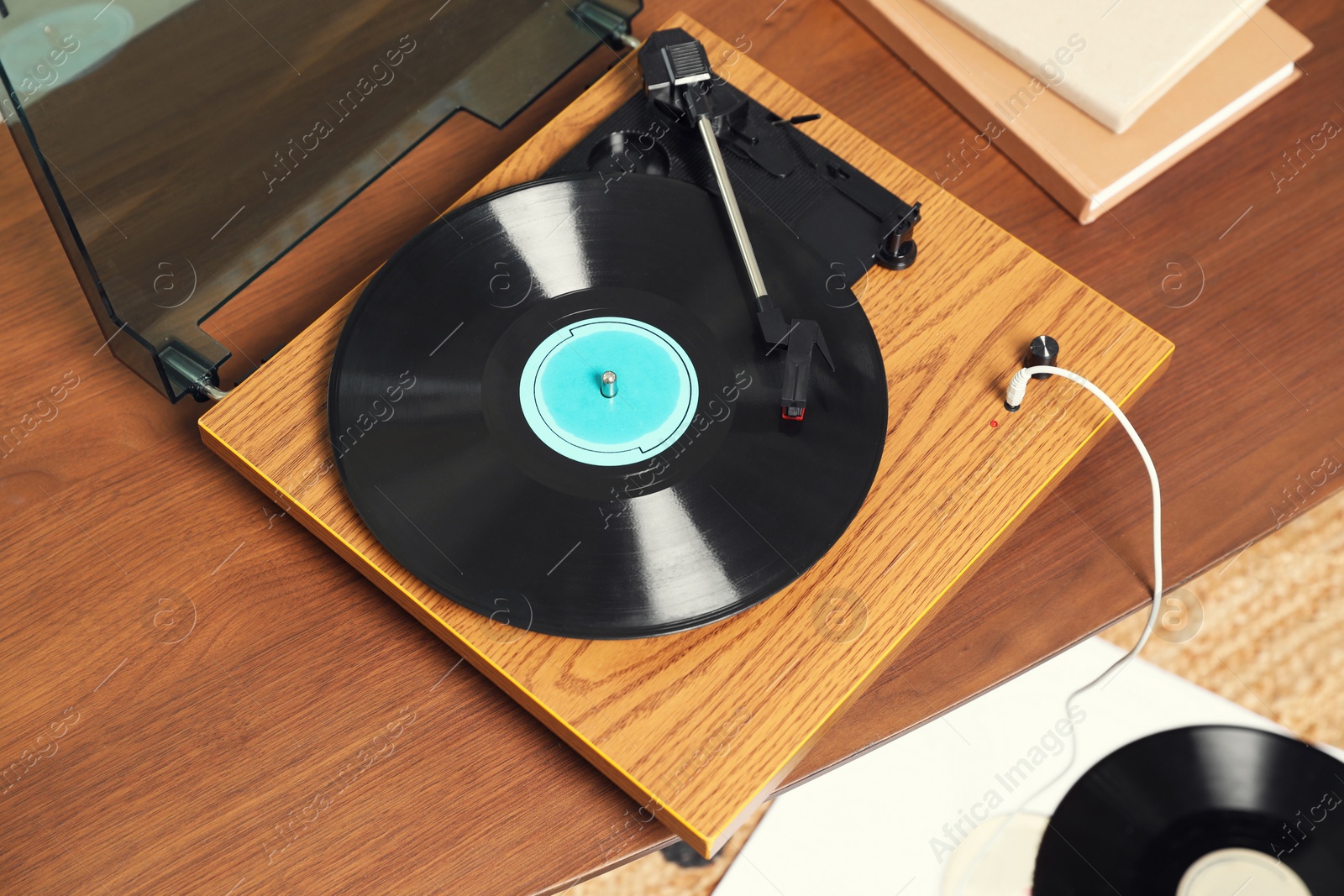 Photo of Stylish turntable with vinyl discs and headphones in room, about view