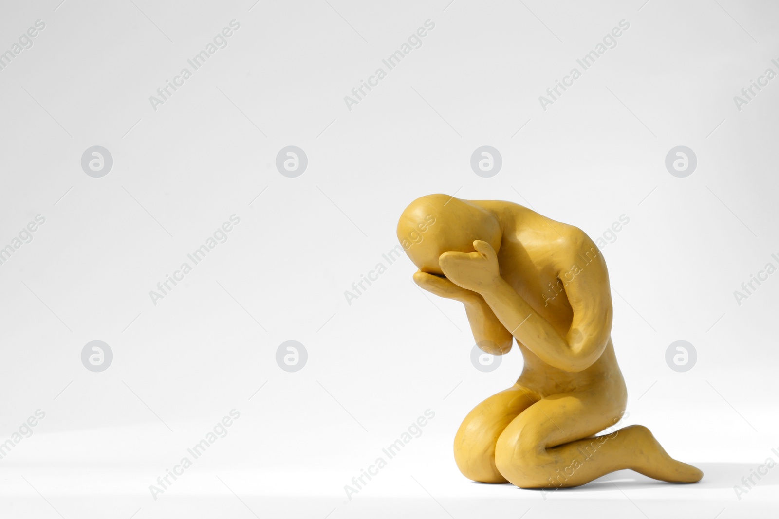 Photo of Plasticine figure of crying human on white background. Space for text