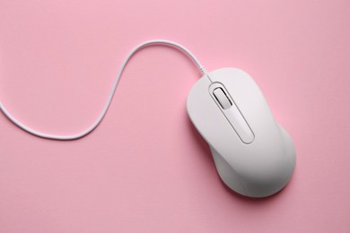 Photo of One wired mouse on pink background, top view