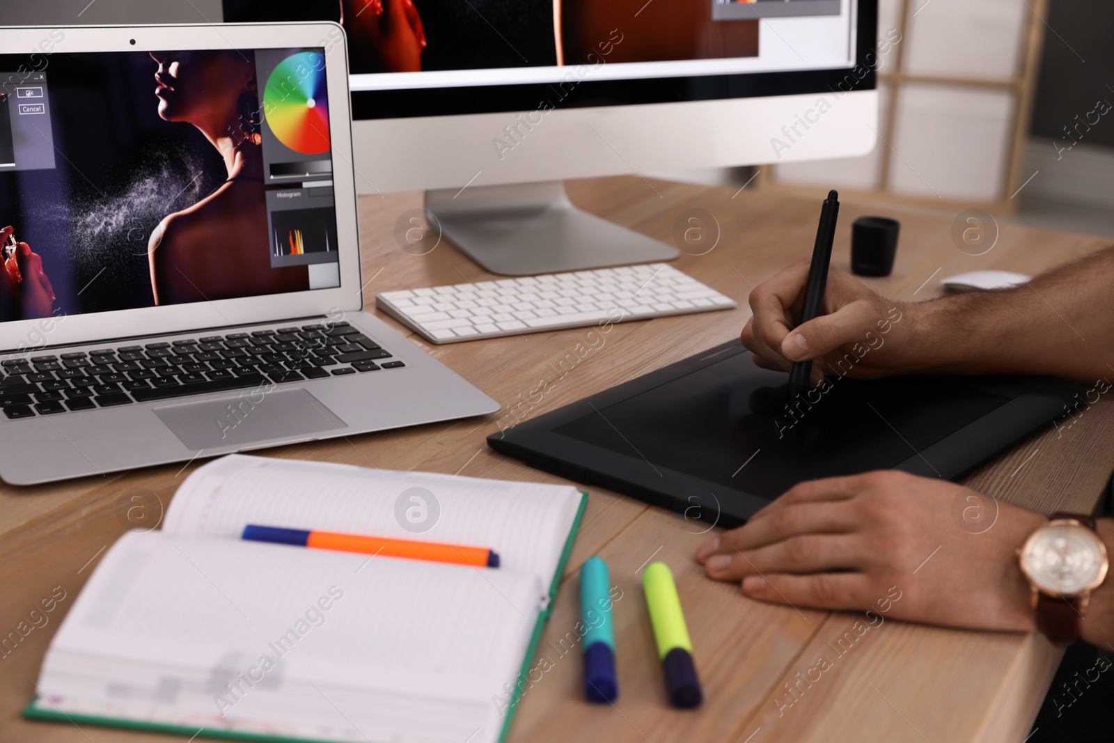 Photo of Professional retoucher working on graphic tablet at table, closeup