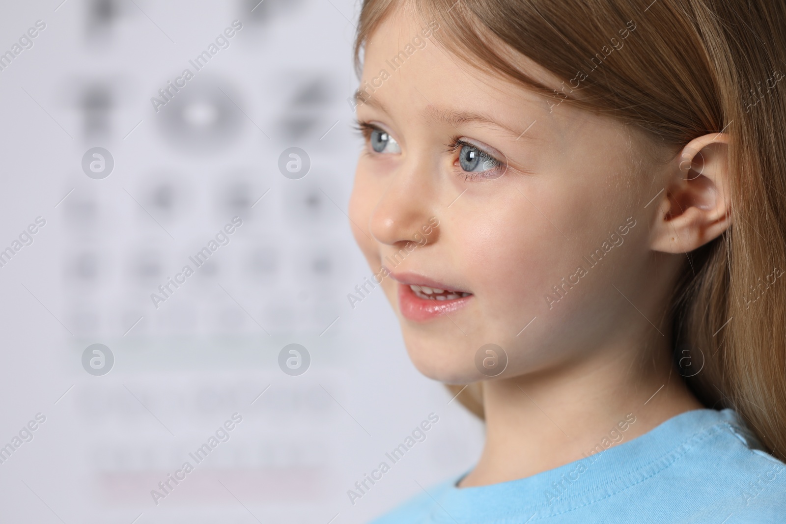 Photo of Cute little girl on blurred background, closeup