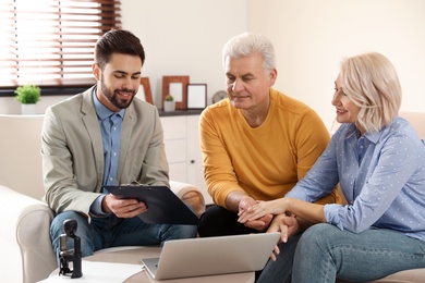 Male notary working with mature couple in office