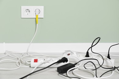 Power strips with different electrical plugs on floor indoors, space for text
