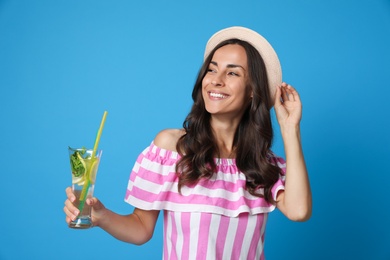 Photo of Young woman with refreshing drink on blue background