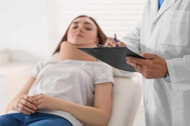 Photo of Orthopedist examining patient with injured neck in clinic, closeup