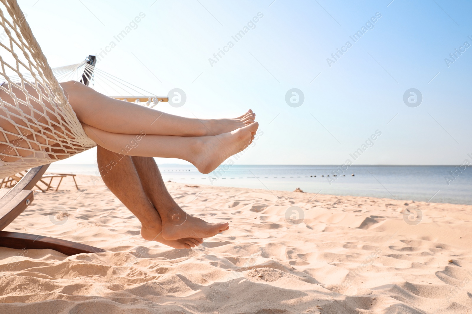 Photo of Young couple relaxing in hammock on beach, closeup