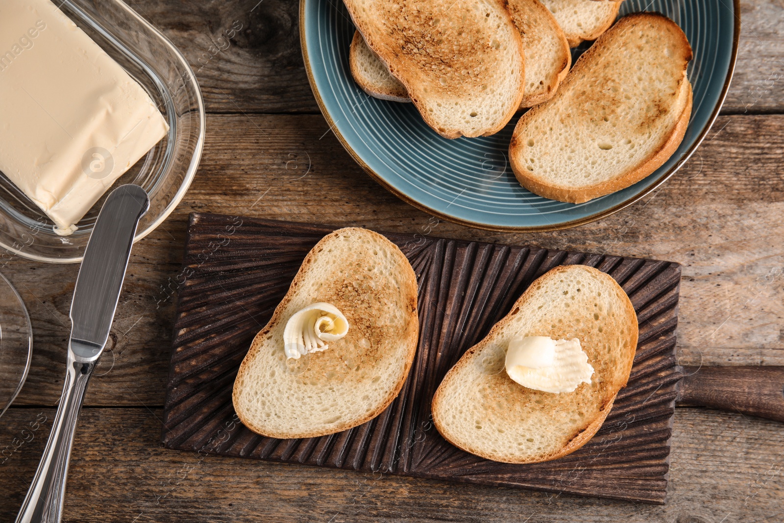 Photo of Flat lay composition with bread and butter on wooden table