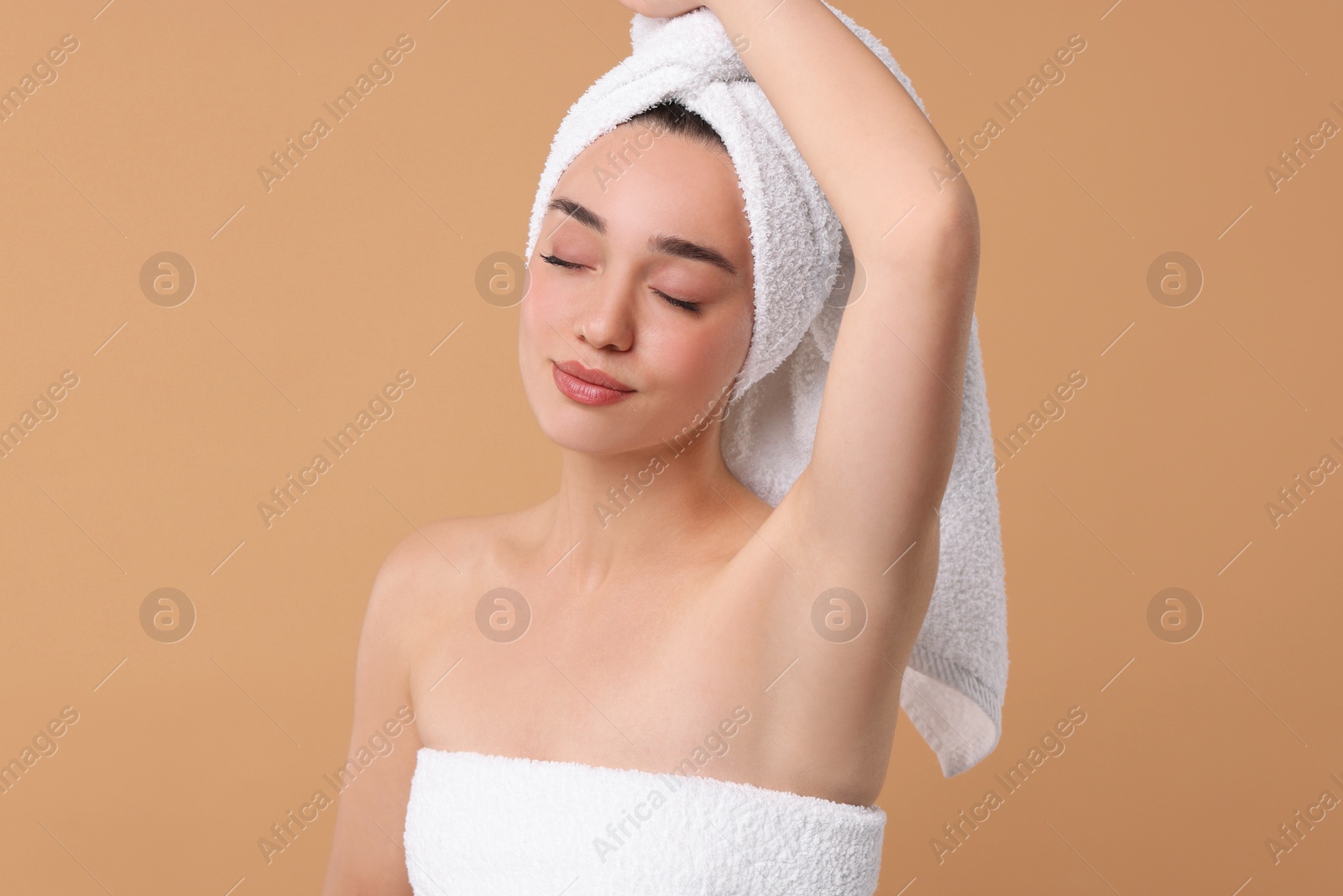 Photo of Beautiful woman showing armpit with smooth clean skin on beige background