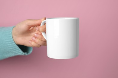 Photo of Woman holding white mug on pink background, closeup