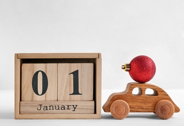 Wooden block calendar, toy car and decor on light background. Christmas countdown