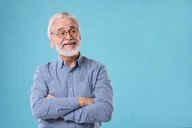 Portrait of stylish grandpa with glasses on light blue background, space for text